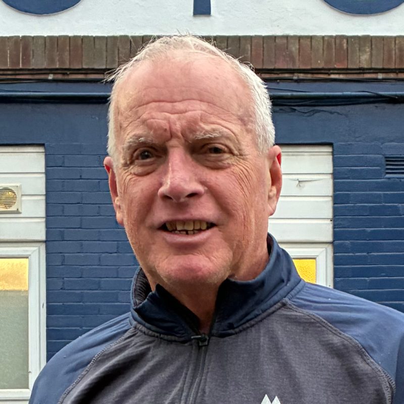 A photo of Tim Rowson from Stockport County Supporters Cooperative stood outside the Stockport County sign at Edgeley Park, Stockport.