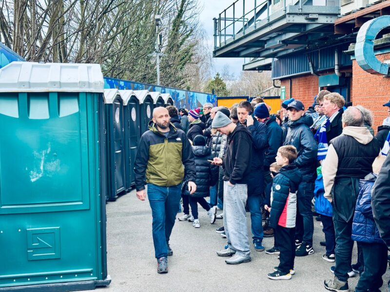 Fans queuing for Portaloos outside the pop side at Edgeley Park.